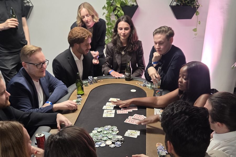 Colleagues playing poker at a fun casino table as the croupier deals at a corporate event