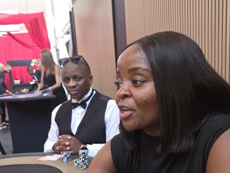 Guest at a poker table with a croupier in a bow tie waiting to deal