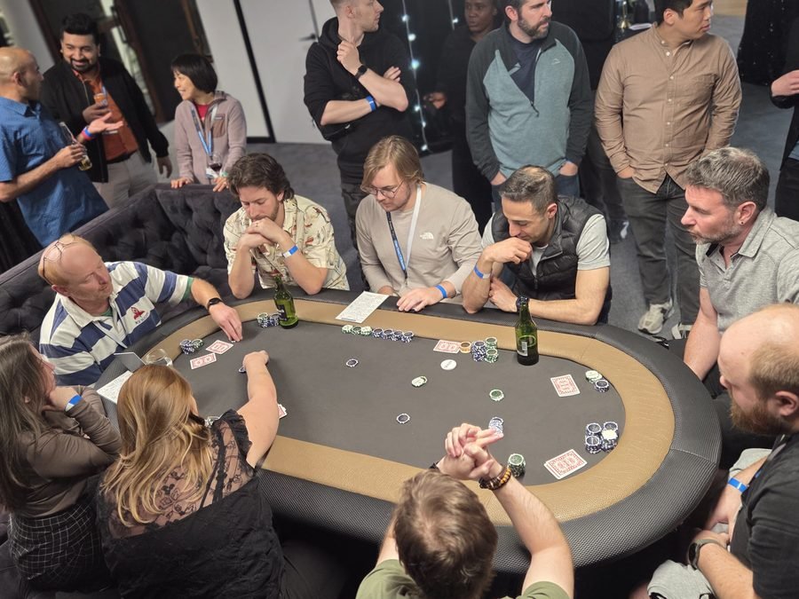 Guests playing poker with onlookers at a corporate fun casino event